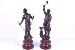 Pair bronze effect figures modelled as metalworkers. Raised on circular wooden bases.