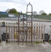 Two assorted metal garden plant supports with finial detail to the top.