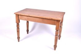 A rectangular 20th century small pine table. Raised on turned tapering supports.