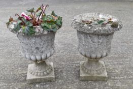 A pair of reconsituted stone pots in the form of urns.