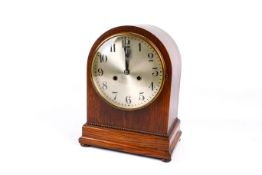 An early 20th century oak cased arched top mantel clock.