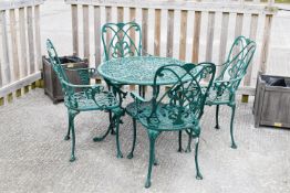 A 20th Century decorative cast metal garden table and four chairs. Painted green.