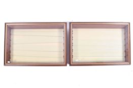 Two wall mounted showcase display cabinets with glass shelves.