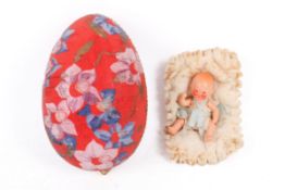 A vintage model doll housed in a Papier-mâché Easter egg.