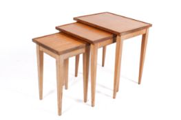 A mid-20th century light teak and beech nest of tables.