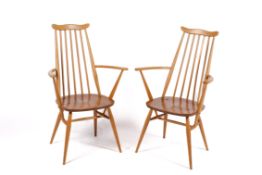 A pair of mid-century, blonde Ercol Goldsmiths carver chairs.