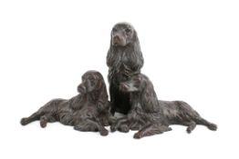 A group of three bronze spaniels in seated and lay down form.