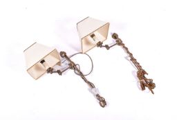 A pair of antique brass effect swing arm wall lights.