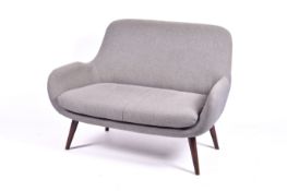 A modern design sofa in grey fabric on tapering walnut finish angular legs. Zip to back.