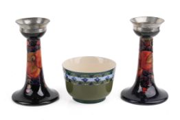 A pair of Moorcroft 'Pommegranate' candlesticks and a Macintyre green glazed bowl.