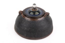 A Japanese style studio pottery vessel with irridescent glass lid.