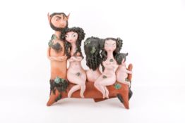 An Art Pottery group of figures depicting a fawn with three semi naked female figures and a baby.
