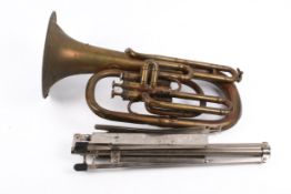 A vintage brass Hawkes & Son alto horn with a music stand.