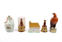 A collection of five assorted novelty ceramic alcohol decanters and contents.