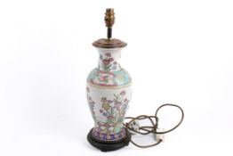 A modern Chinese famille rose style porcelain vase table lamp. Raised on a turned wooden base.
