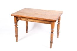 A vintage pine kitchen table. Having rectangular top, raised on turned tapering supports.