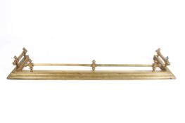 A Victorian brass fireplace fender.