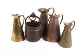 Four assorted brass or copper pitchers and a hand forged iron bucket.
