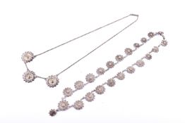 Two white metal floral necklaces. One featuring three moulded flower charms on a chain, 6.