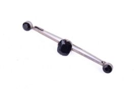 A silver and dark blue stone bar brooch.