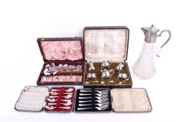 A small group of boxed silverplated table items and a claret jug.