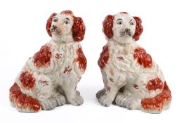 A pair of Staffordshire style King Charles Spaniel dog figures in earthenware pottery,