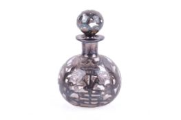 An Art Nouveau white metal mounted perfume bottle.
