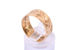 A 22ct gold band ring. With quatrefoil flower pattern in relief, hallmarked, width of band 0.