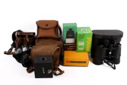 An assortment of vintage film cameras, binoculars and accessories.