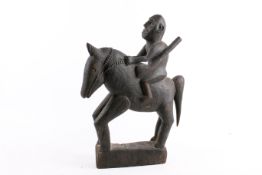 West African tribal carving of a man on horse back. Raised on an integral plinth base.