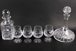 Four Stuart lead crystal brandy glasses and two decanters.