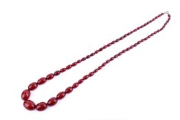 A vintage necklace of graduated red bakelite beads. Largest bead 2.8cm x 2cm, total L84cm.