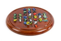 An Edwardian mahogany solitaire board with coloured marbles.