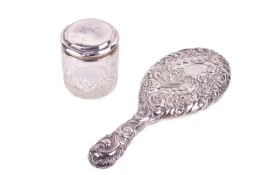 A silver backed hand mirror and lidded pot.
