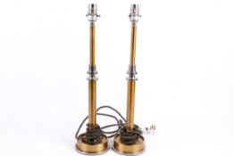 A pair of contemporary Pooky Metro table lamps. Raised on circular bases.