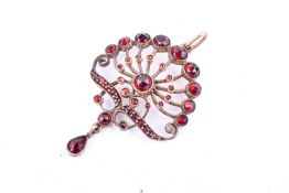 An early 20th century openwork pendant set with round faceted garnets.