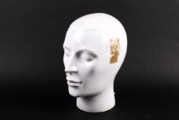 A white glazed ceramic head modelled with short hair.