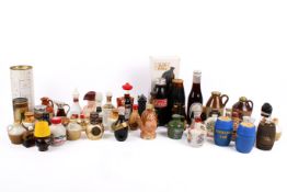 A collection of assorted novelty ceramic or glass alcochol miniatures, many with contents.