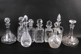 A collection of eight assorted cut glass spirit decanters and a claret jug, all with stoppers.