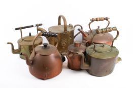 A group of four assorted brass and copper kettles with two watering cans.