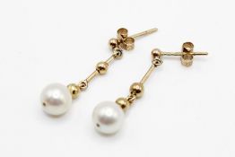 A pair of 9ct gold (tested) cultured akoya pearl drop earrings. Each cultured pearl of 6.