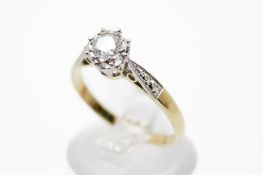 A yellow metal diamond solitaire ring. The illusion set round cut diamond circa 3.