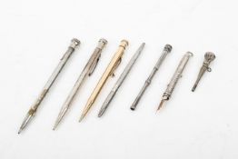 Seven silver and white metal pens and propelling pencils. Including a stamped 'Tiffany & Co.