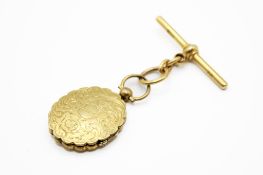 An oval hinged picture locket suspended from an 18ct gold T-bar fitting.