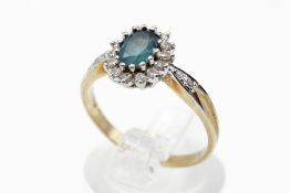 A 9ct gold cluster ring. Set with one oval faceted topaz and round brilliant cut diamonds of 0.