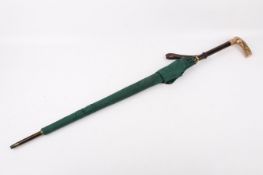 A yellow metal handled walking cane converted into an umbrella.