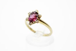 An 18ct gold and garnet dress ring. The oval cut garnet of circa 1.