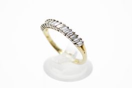 A yellow metal and diamond ring. Set with fifteen baguette cut diamonds, each circa 0.