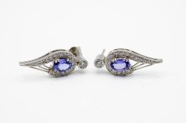 A pair of platinum and tanzanite earrings.