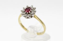 An 18ct gold diamond and ruby ring. Set with one oval faceted ruby of 0.